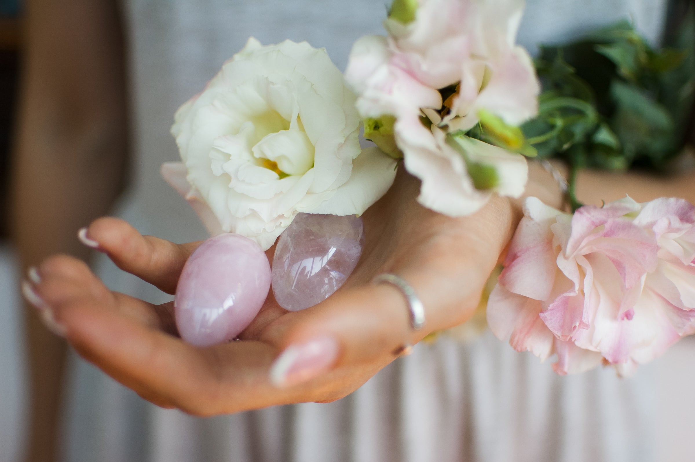 Woman holding small rose quartz yoni eggs 